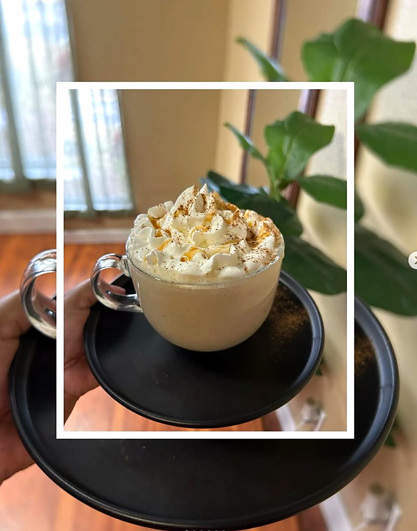 Latte in a glass mug topped with whipped cream